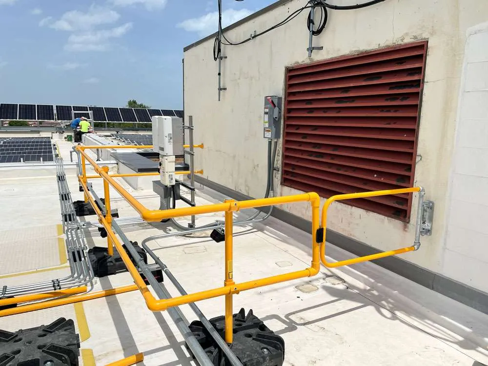 Bright yellow portable guardrail section providing OSHA-compliant fall protection.